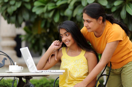 Loving mother and daughter with laptop in outdoors